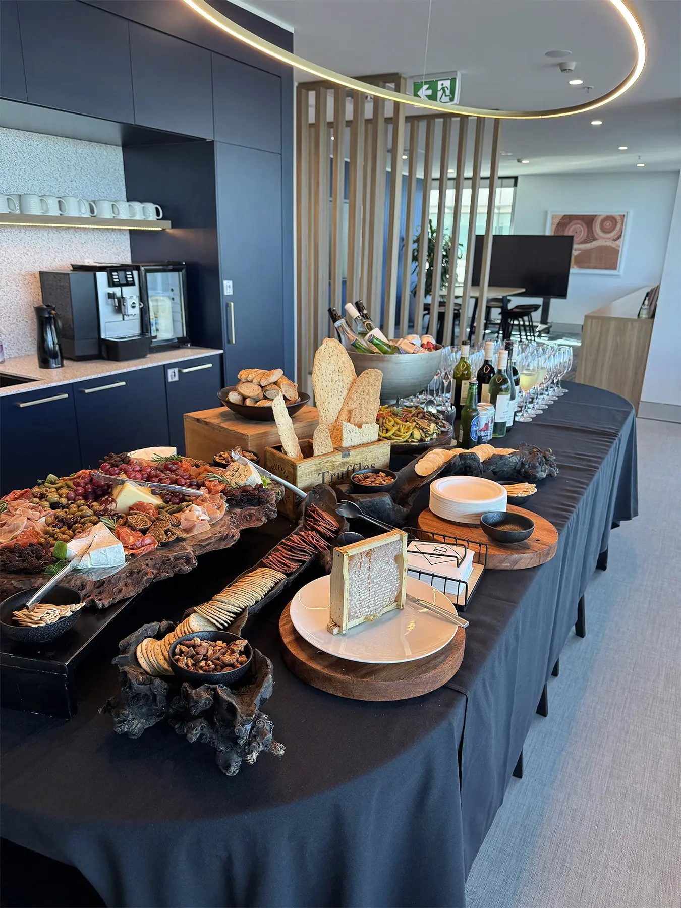 Long grazing table with charcuterie boards, cheeses, breads, honeycomb and wine