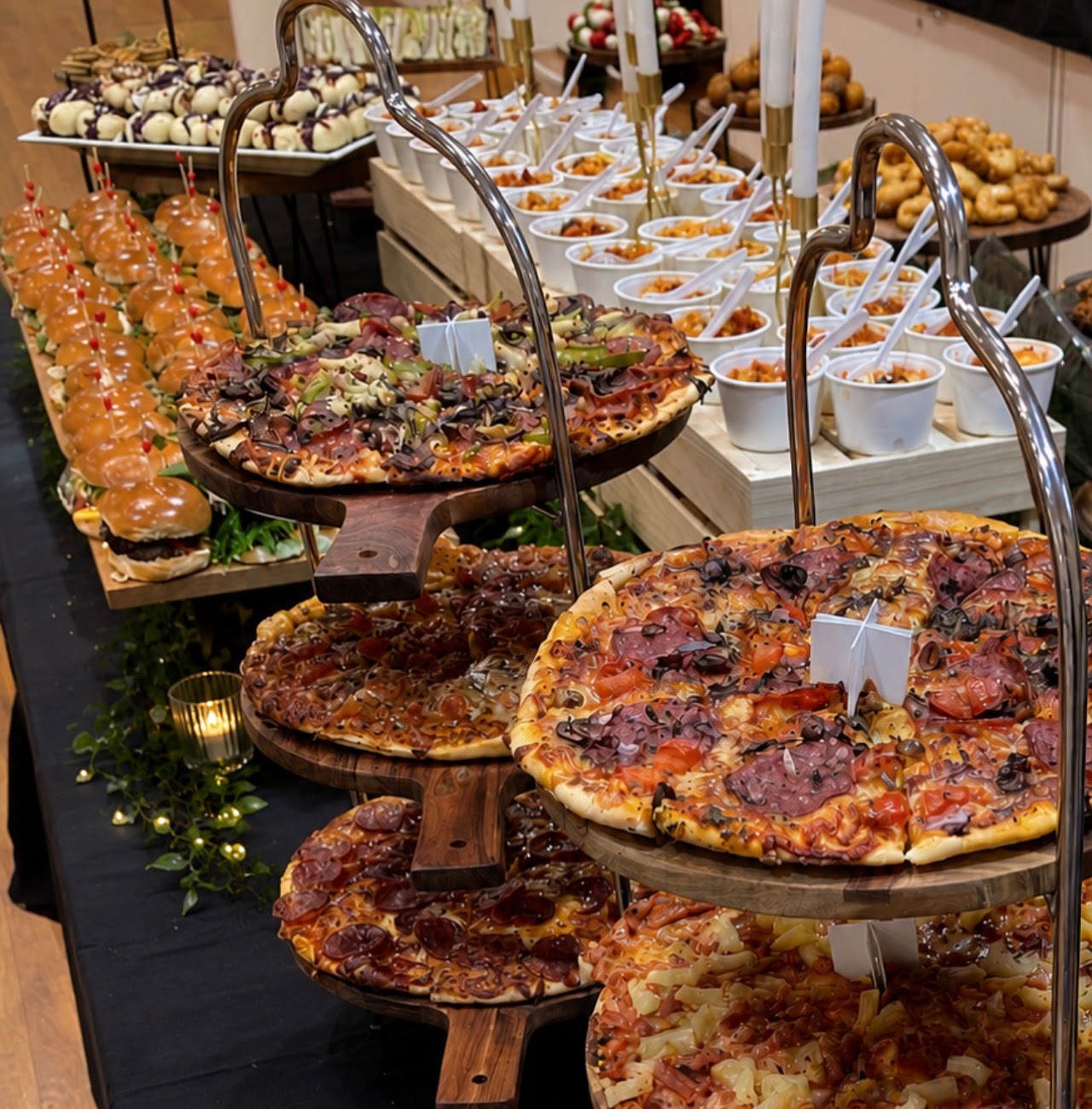 Main catering table with woodfired pizzas, sliders and pasta cups