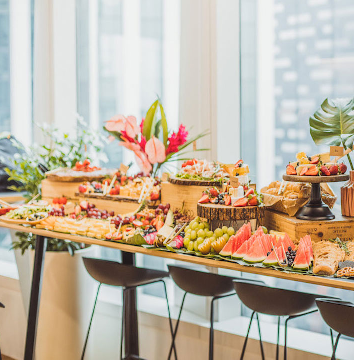 Grazing bar styled along a window with platters and fresh fruit