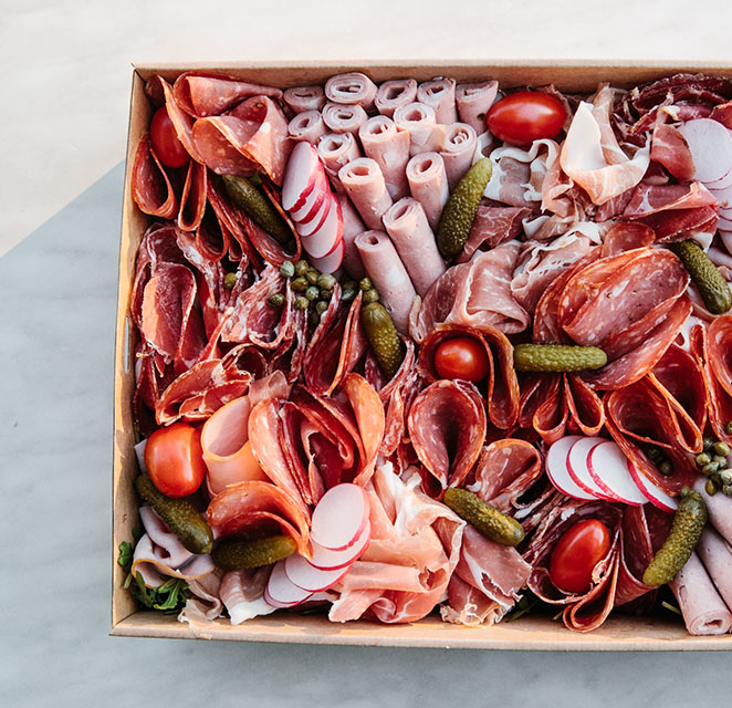 Antipasto box of cured meats, pickles and fresh vegetables